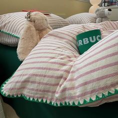 two teddy bears are sitting on pillows in a room with green and white bedding