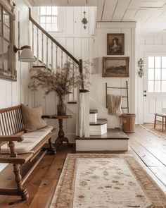 a living room filled with furniture and a stair case next to a wooden table on top of a hard wood floor