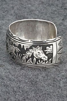 This expertly crafted sterling silver bracelet featuring horses was made by Navajo silversmith Richard Singer. The back is signed R Singer and stamped .925.Size: 5 5/8" (will fit up to a 6 3/4" wrist)Gap: 1 1/8"Width: 1"Free shipping on all orders! We ship with USPS and always include tracking. All orders ship within a day of payment.Returns are accepted up to 30 days after you receive your order. Just send us a message. Our shop offers cash back or store credit. The item must be returned in new Handmade Western Sterling Silver Cuff Bracelet, Western Sterling Silver Cuff Bracelet Gift, Handmade Western Silver Cuff Bracelet, Western Sterling Silver Adjustable Bracelet Stamped 925, Western Sterling Silver Cuff Bracelet, Adjustable Etched Southwestern Sterling Silver Bracelet, Adjustable Etched Sterling Silver Southwestern Bracelet, Adjustable Sterling Silver Western Cuff Bracelet, Western Sterling Silver Bracelets