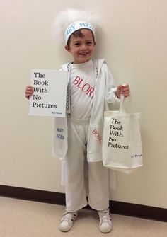 a little boy dressed up as a doctor and holding two books in his hands while standing next to a wall