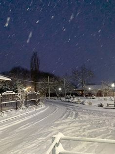 a snow covered street at night with lights on