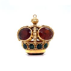 Make your yellow gold chain stand out with this Mid-Century crown pendant in 18 karat yellow gold! Five (5) 4.50 carat amber-hued citrine gems and four (4) seed pearls decorate the top of the crown. Ten (10) tsavorite garnets, each with a blue-green hue, are bezel set around the base of the crown. Starburst engravings and a decorative bail in 18K yellow gold add texture and dimension to this opulent crown pendant. A sweet gift idea for any Mid-Century jewelry lover! Composition: 18 Karat Yellow Luxury Jeweled Yellow Gold Jewelry, Luxury Yellow Gold Jeweled Necklace, Luxury Jeweled Yellow Gold Necklace, Gold Jeweled Crown Jewelry, Luxury Jeweled Pendant Jewelry, Formal Yellow Gold Jeweled Jewelry, Formal Jeweled Yellow Gold Jewelry, Luxury 14k Gold Amber Jewelry, Luxury Round Crown Design Jewelry