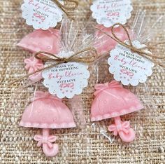 small pink baby shower favors in cello bags with twine bows and tags on them