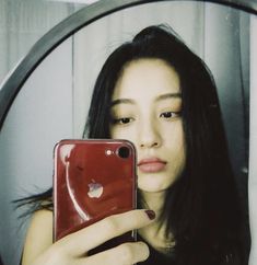 a woman taking a selfie in front of a mirror with an apple logo on it