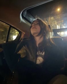 a woman sitting in the back seat of a car