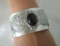 This beautiful silver plated cuff bracelet has a black onyx stone set on silver plated embellishments and silver plated gothic wings on the sides. Adjustable. Bohemian Cuff Jewelry For Formal Occasions, Metal Bangle With Jewels, Elegant Adjustable Cabochon Jewelry, Elegant Adjustable Filigree Jewelry, Ornate Metal Bracelet Jewelry, Elegant Adjustable Filigree Cuff Bracelet, Formal Cabochon Bracelet Jewelry, Ornate Bangle For Formal Occasions, Ornate Formal Bangle Jewelry