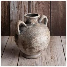 an old vase sitting on top of a wooden table