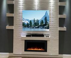 a television mounted on a wall with a fire place in front of it and mountains in the background