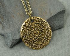 Men's coin necklace features an ancient style ornate antique gold pendant. Your choice of chain lengths - 18, 20, 24, 30 Pendant is made of antique gold plated pewter and is 15/16 inches in diameter (24mm). Find more men's jewelry styles here - https://www.etsy.com/shop/CharleneSevier?ref=hdr_shop_menu&section_id=10866473 Antique Gold Pendant, Crow Pendant, Boys Necklace, Raven Necklace, Jewelry Styles, Hippie Earrings, Necklace Antique, Medallion Necklace, Mens Pendant