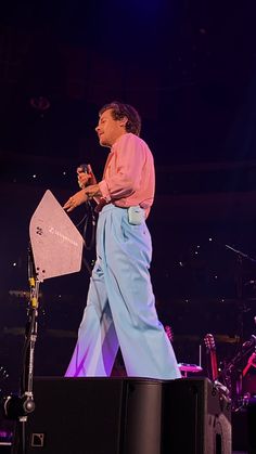 a man standing on top of a stage next to a microphone in front of him