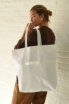 White A versatile 2-way bag that switches effortlessly from shoulder bag to handbag. Fold it and use small removable strap to pack down to a small rectangle for easy carrying. Super lightweight, durable and water resistant 1.9oz ripstop nylon (100% nylon) Zipper closure, inner zipper pocket, unlined interior shoulder bag - 18.5" (W) 19.5" (H) 5" (D) 10" drop Hand bag - 18.5" (W) 12" (H) 45" (D) 2.5" drop Made in USA Rectangular Nylon Shoulder Bag For Everyday, Rectangular Nylon Shoulder Bag With Removable Pouch, Rectangular Nylon Shoulder Bag With Top Carry Handle, Functional White Shoulder Bag With Top Carry Handle, White Nylon Shoulder Bag For Travel, Rectangular Nylon Bag For On-the-go, White Nylon Bags With Double Handle, Rectangular Nylon Shopping Bag, Packable Rectangular Nylon Bag