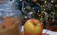 an apple sitting on top of a table next to a glass jar filled with sand