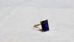 "A very high quality VVS1 dark blue iolite rectangle, emerald cut gem takes centerstage with this beautiful simple design. It's a modern/classic look that is very easy to wear and is sure to become one of your everyday ring. The shank is a split design, semi-rounded and 1mm thick. The size is 7. I ONLY MADE ONE BECAUSE THERE IS ONLY ONE OF THIS GEM IN THAT PARTICULAR COLOR AND SHAPE, BUT THIS RING CAN BE ADJUSTED TO ANY SIZE. PLEASE ALLOW A MINIMUM OF 3 WEEKS FOR ME TO RESIZE THE RING. IOLITE is Timeless Tanzanite Rings As Gift, Timeless Tanzanite Rings For Gifts, Formal Square Cut Sapphire Ring, Elegant Sapphire Ring With Square Cut And Prong Setting, Elegant Square Cut Sapphire Ring With Prong Setting, Elegant Sapphire Ring For Anniversary, Square Cut, Elegant Square-cut Sapphire Ring For Anniversary, Elegant Square Cut Sapphire Ring For Anniversary, Elegant Square Cut Sapphire Anniversary Ring