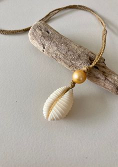 Hawaiian endemic cowrie shell (Granulated Cowrie) paired with a gold freshwater pearl on braided waxed twine. 19 inch cord and fitted with a puka shell closure. The braided waxed twine chain is durable and can be worn in the ocean as well as in other active pursuits! Braided Natural Jewelry As Gift, Natural Braided Jewelry Gift, Natural Color Braided Jewelry Gift, Natural Braided Jewelry As Gift, Gold Sliding Knot Jewelry For Vacation, White Bohemian Jewelry With Waxed Cord, White Jewelry With Adjustable Cord For Vacation, Bohemian White Waxed Cord Jewelry, White Adjustable Nylon Cord Jewelry