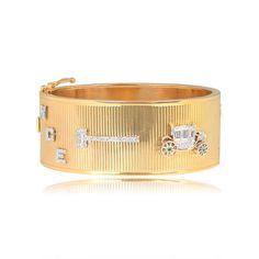 A Retro era bracelet featuring a 14k yellow gold bangle and platinum Art Deco charms. The charms are set with single cut diamonds. Starting at the clasp and in order from left to right, the charms are: the letters N G E set diagonally, a judge’s gavel, a carriage with milgrain detail and emerald accents on the wheels, a second gavel, a courthouse, a car, and two people with engraved faces. The people are depicted holding hands, one wearing a top hat and the other with a hat and veil. The faces a Hat And Veil, Era Bracelet, Estate Diamond Jewelry, Retro Era, Yellow Gold Bangle, Gold Bangle, Art Deco Era, Featured Art, Vintage Bracelets