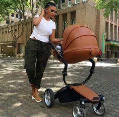 a woman standing next to a baby stroller