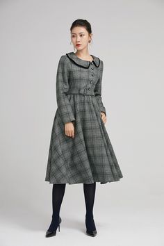 "Simple. With its pleated skirt and grayscale plaid pattern, this vintage wool dress epitomizes classic styling. She's all class and quality with no bells or whistles. Near-perfect vintage condition, designed with lapel collar, long sleeves and tie belt waist, it will be your favorite one of your wardrobe. Details: * 35% wool blend, 35% fiber and polyester, 30% nylon * Polyester lining * long sleeves * tie belt waist * lapel collar * button decoration in front * knee length * back zipper closure Classic Long Sleeve Tweed Dress For Winter, Elegant Midi-length Plaid Dress For Fall, Classic Vintage Dress For Work In Fall, Elegant Plaid Midi Dress For Fall, Classic Vintage Dress For Fall Workwear, Vintage Plaid Dress For Winter, Vintage Plaid Winter Dress, Elegant Fall Plaid Midi Dress, Classic Fall Vintage Dress For Workwear