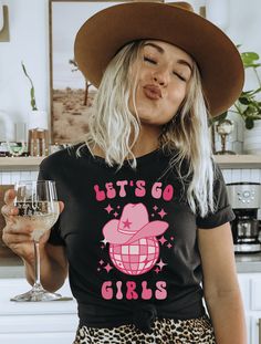 Get ready to be OBSESSED with your new "Let's Go Girls" western graphic tee. It's the cutest and most trendy way to emit all those important country western vibes! This T-shirt makes the perfect bachelorette party, birthday party or concert tee! Find the matching "Man I Feel Like a Bride" shirt here: https://www.etsy.com/listing/1443816374 DETAILS * Bella + Canvas Unisex Premium T-Shirt  * Soft and lightweight  * 100% combed and ring-spun cotton  * Athletic Heather is 90% combed and ring-spun co Cute Party T-shirt With Text Print, Cute Fitted Party T-shirt, Party T-shirt With Funny Print, Cute Party Shirt With Graphic Print, Cute Graphic Print Shirt For Party, Disco Bridal Party, Bachelorette Disco, Nashville Bachelorette Party Shirts, Bachelorette Party Tshirts