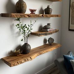 three wooden shelves with plants and vases on them