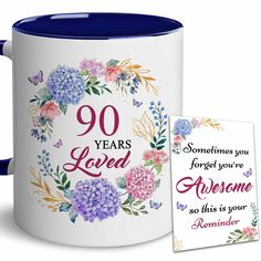 a blue and white coffee mug with the words 90 years loved on it next to a card