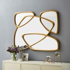 a white dresser topped with a mirror next to a vase filled with flowers