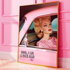 a framed photograph of a barbie doll in a pink car