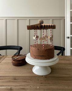 a chocolate cake sitting on top of a wooden table next to a plate with candles