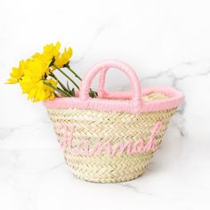 a basket with flowers in it sitting on a marble counter next to a white wall