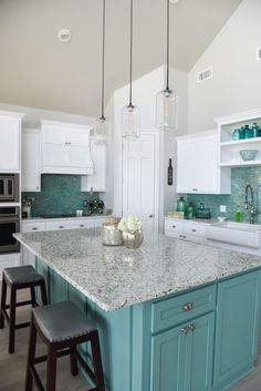 a large kitchen island with two stools in front of it and an oven on the other side