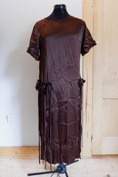 Gorgeous brown silk crepe flapper dress. It has silk flower decorations at each hip, with long, decorative strings hanging from them. The true color is a really brown brown -- like a brown crayon. I has short sleeves with ruffled decoration around the edges. The neckline opens on one shoulder with 2 metal snaps, which are both secure. There is a large hole under the proper right armpit (pictured), and a small hole in the seam of the proper left armpit. There is white discoloration at the interio Deodorant Stains, Brown Silk, Brown Brown, Silk Flower, Silk Crepe, Dress Clothes For Women, Silk Flowers, Flower Decorations, Labour Day