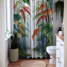 the shower curtain is decorated with tropical plants