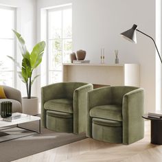 a living room with two green chairs and a coffee table in front of the window