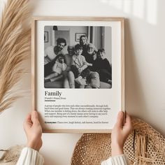 a person holding up a framed photo with family on it next to a straw hat