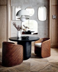 a dining room table with chairs and a vase on the table in front of it