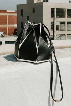 Elevate your accessories game instantly with the Lulus Unparalleled Style Black and White Color Block Bucket Bag! Smooth vegan leather, in contrasting hues of black and white in a geometric-style design, shapes this structured bucket bag with a flat bottom silhouette and a unique drawstring top that cinches with slender, twin tote handles. A slender, detachable shoulder strap allows for various styling options, while the roomy interior keeps all your must-have essentials safe and sound! Gold hardware. Bag Measures 7" Wide, 7" Tall, 6" Deep. Detachable 37" Adjustable Strap. 100% Man Made Materials. Imported. Lulus | Unparalleled Style Black and White Color Block Bucket Bag | Vegan Friendly. Gold Har, Design Shapes, Drawstring Bucket Bag, Drawstring Top, Black And White Color, Black And White Colour, Vegan Friendly, Style Design, Handbag Accessories