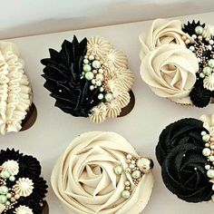 six cupcakes decorated with black and white flowers