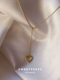 Product Details + Care  - 18K Gold Dipped Over Brass - Brass: Copper + Zinc Alloy - 1 Necklace - Wipe Clean  - Imported  Dimensions - Chain Approximately 16" Have a question? Please message info@shopsweetpeeps.com and our support team will get back to you in 48 hours. Gold Pendant Lariat Necklace As Gift, Valentine's Day Jewelry With Adjustable Dangle Chain, Valentine's Day Dangle Jewelry With Adjustable Chain, Gold Heart Dangle Necklace With Adjustable Chain, Gold Heart Charm Lariat Necklace, Heart-shaped Lariat Necklace With Clavicle Chain, Gold Lariat Necklace With Heart Charm, Adjustable Clavicle Chain Heart Necklace For Valentine's Day, Adjustable Heart Necklace With Clavicle Chain For Valentine's Day