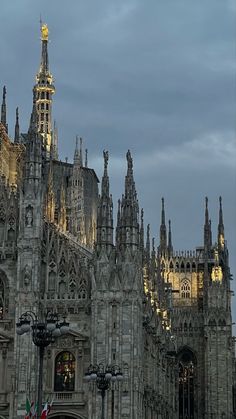 a large cathedral with many spires and lights on it's sides at night