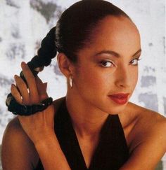 a woman with her hair in a pony tail and wearing an elegant black halter top