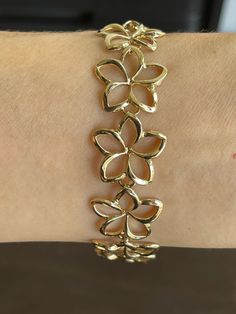 Elegant And Beautiful Hawaiian 14K Solid Yellow Gold 18mm Plumeria Flower Lei Bracelet 7 1/2 Inches High Polished Finish 14 Karat Solid Yellow Gold GUARANTEED, Authenticated with a 14K Stamp Made With Highest Quality Craftsmanship Solid 14K Yellow Gold Plumeria Flower Lei Bracelet Length 7.5 Inches Total Weight 11.8 grams Solid 14K Yellow Gold Plumeria Flower Width 18 Millimeters Amazing Gift For Family And Friends! Jewelry Gift Box Included! Gold Bracelet With Flower Charm, Gold Bracelet With Flower Charm And Round Shape, Gold Flower Shaped Bracelets For Formal Occasions, Flower Shaped Anniversary Bracelets, Anniversary Bracelets With Flower Charm, Formal Jubilee Bracelet With Flower Shape, Flower Shaped Bracelet With Flower Charm For Anniversary, Flower Charm Bracelet For Anniversary, Hispanic Jewelry