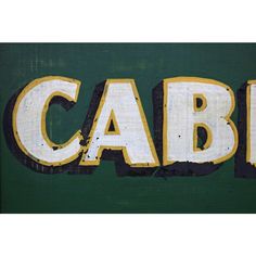 the word cabb is painted in white and yellow on a green background with black trim