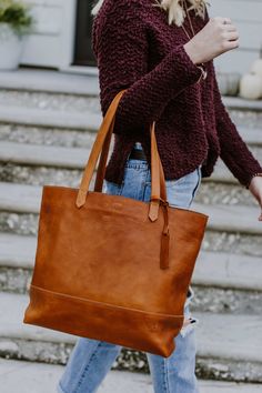 Beautiful. That’s what you call this large saddle tan leather tote bag. The large size is just right, whether you’re carrying a laptop or your favorite pen and journal. The full grain leather with minimalistic design is lightweight for its size. The handmade stitching details make it a fun addition to any outfit — for travel, work, or play. Leather Tote Bag Outfit, Handbag Inspiration, Buffalo Jackson, Leather Working Projects, Linen Style Fashion, Leather Tote Handbags, Tan Leather Tote, Diy Leather Bag, Leather Tote Bags