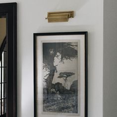 a black and white photo hanging on the wall next to a framed print with a deer