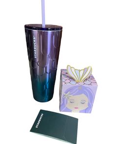 a purple tumbler next to a box with a toothbrush in it and a card