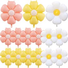 four flower shaped lollipops with yellow, pink and white flowers on them