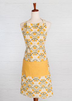 a dress on a mannequin with an orange and yellow flower pattern in the center