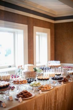 a table topped with lots of desserts next to two windows