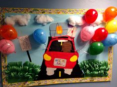 a bulletin board with balloons and a car