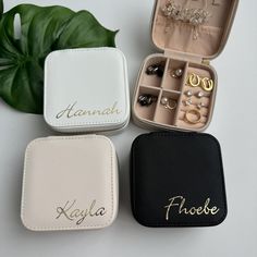 three personalized jewelry boxes with their names on them next to a plant and some other items