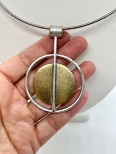 Modern pendant. Silver and gold metal. Not sterling. Modern Gold-plated Necklaces, Modern Gold Plated Necklaces, Modern Metal Necklace With Oval Pendant, Modern Metal Oval Pendant Jewelry, Modern Metal Jewelry With Oval Pendant, Modern Hallmarked Pendant Necklaces, Modern Hallmarked Pendant Necklace, Modern Round Large Pendant Jewelry, Modern Jewelry With Large Round Pendant